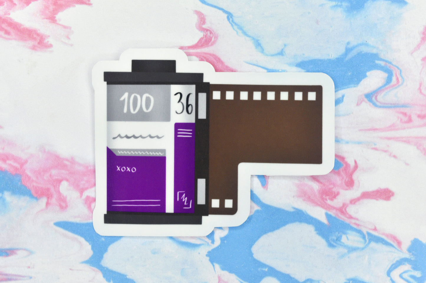 An LGBTQ+ pride vinyl sticker depicting a roll of film in the asexual pride flag colours.