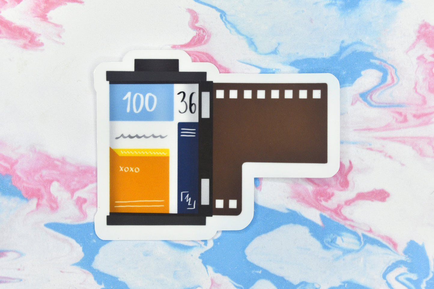 An LGBTQ+ pride vinyl sticker depicting a roll of film in the aroace pride flag colours.