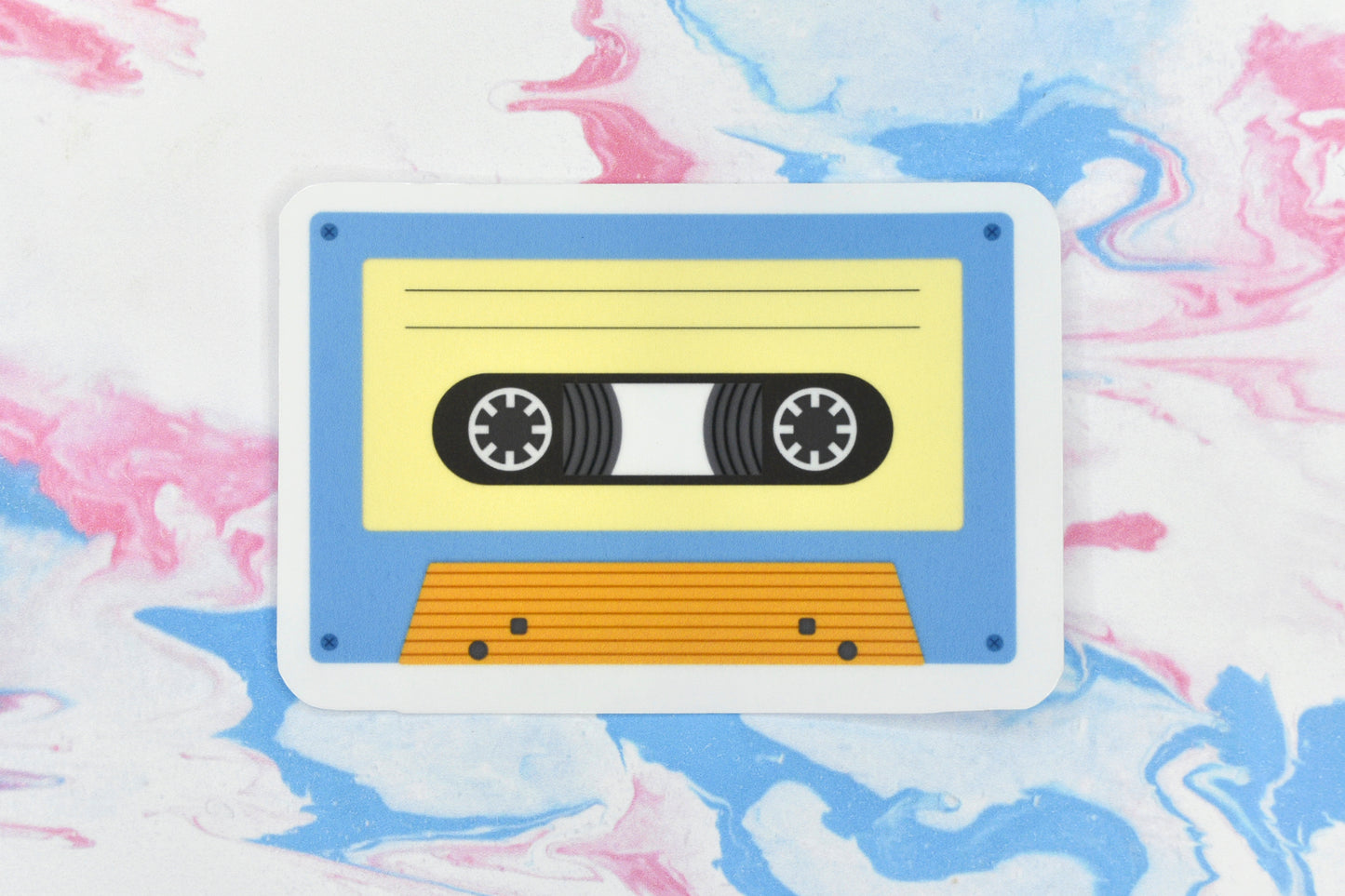 An LGBTQ+ pride vinyl sticker depicting a cassette tape in the aroace pride flag colours.