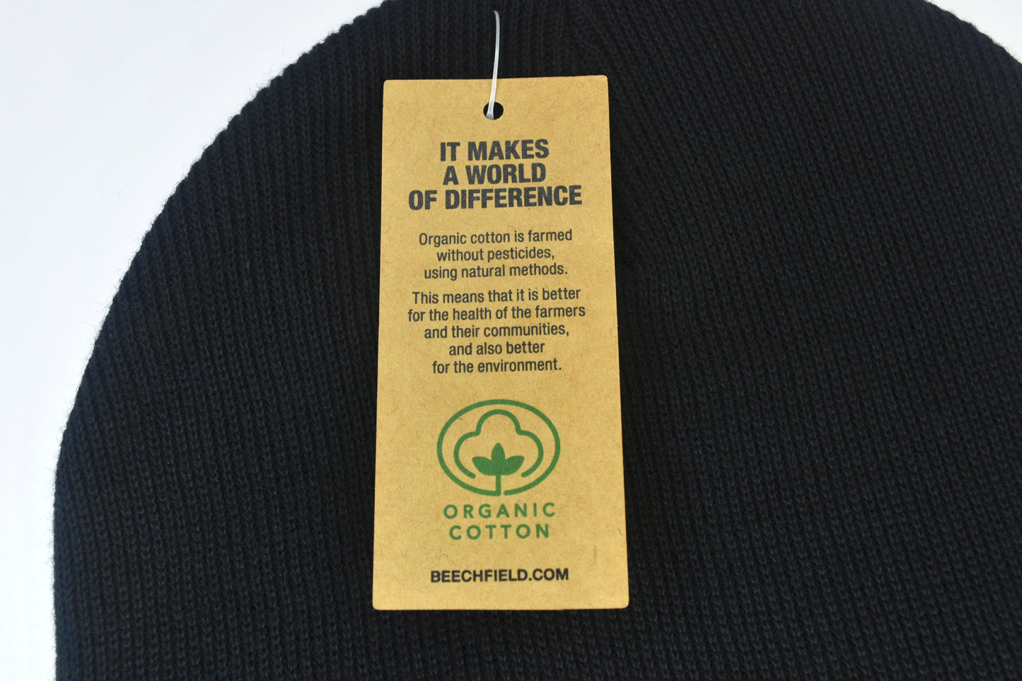 A close up photo of the label on the beanies which gives details on the sustainability of the item and details on the organic cotton.