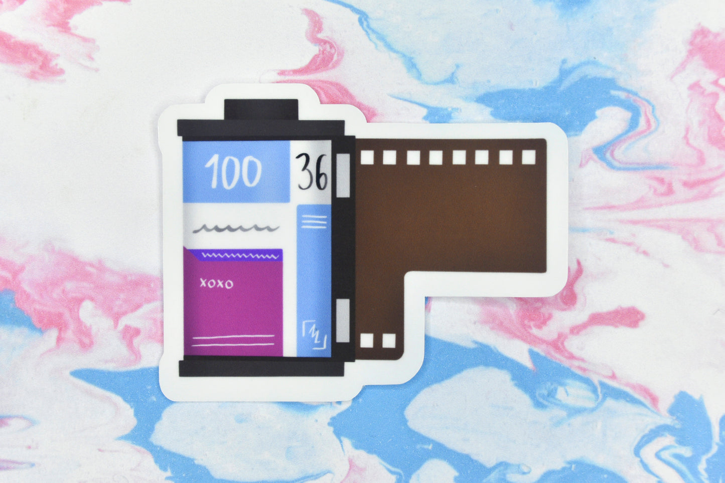 An LGBTQ+ pride vinyl sticker depicting a roll of film in the bisexual pride flag colours.