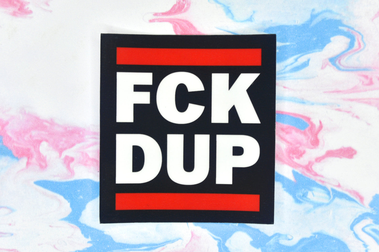 A vinyl sticker with bold white text in the style of the RUN DMC logo with text reading "FCK DUP"