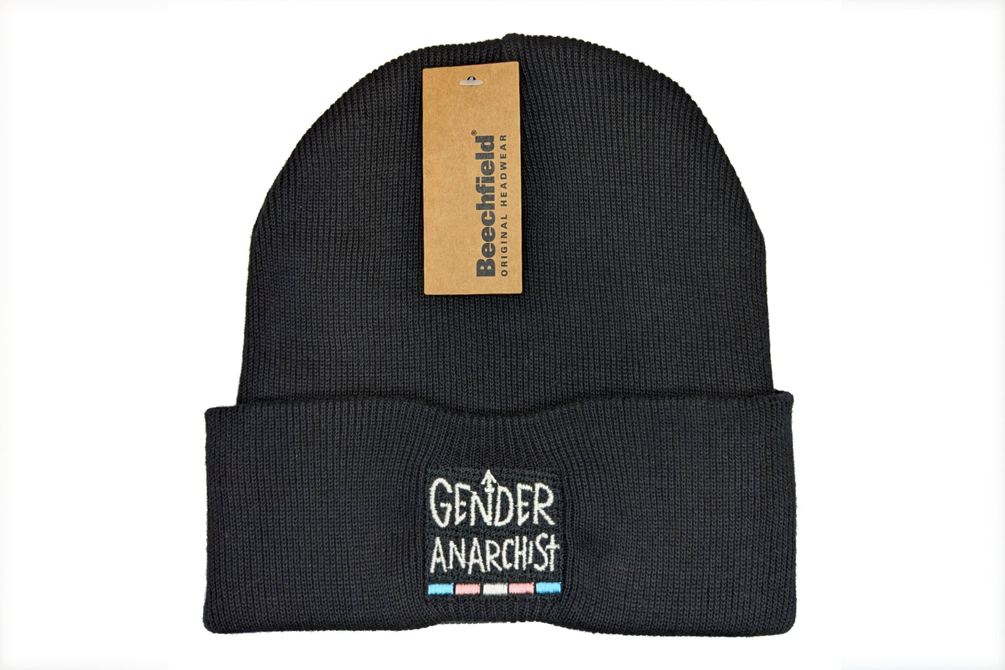 A photo of a black cuffed beanie with a trans pride design embroidered on the cuff. The design consists of white text reading "Gender Anarchist" with a thin band in the trans pride flag colours below it.