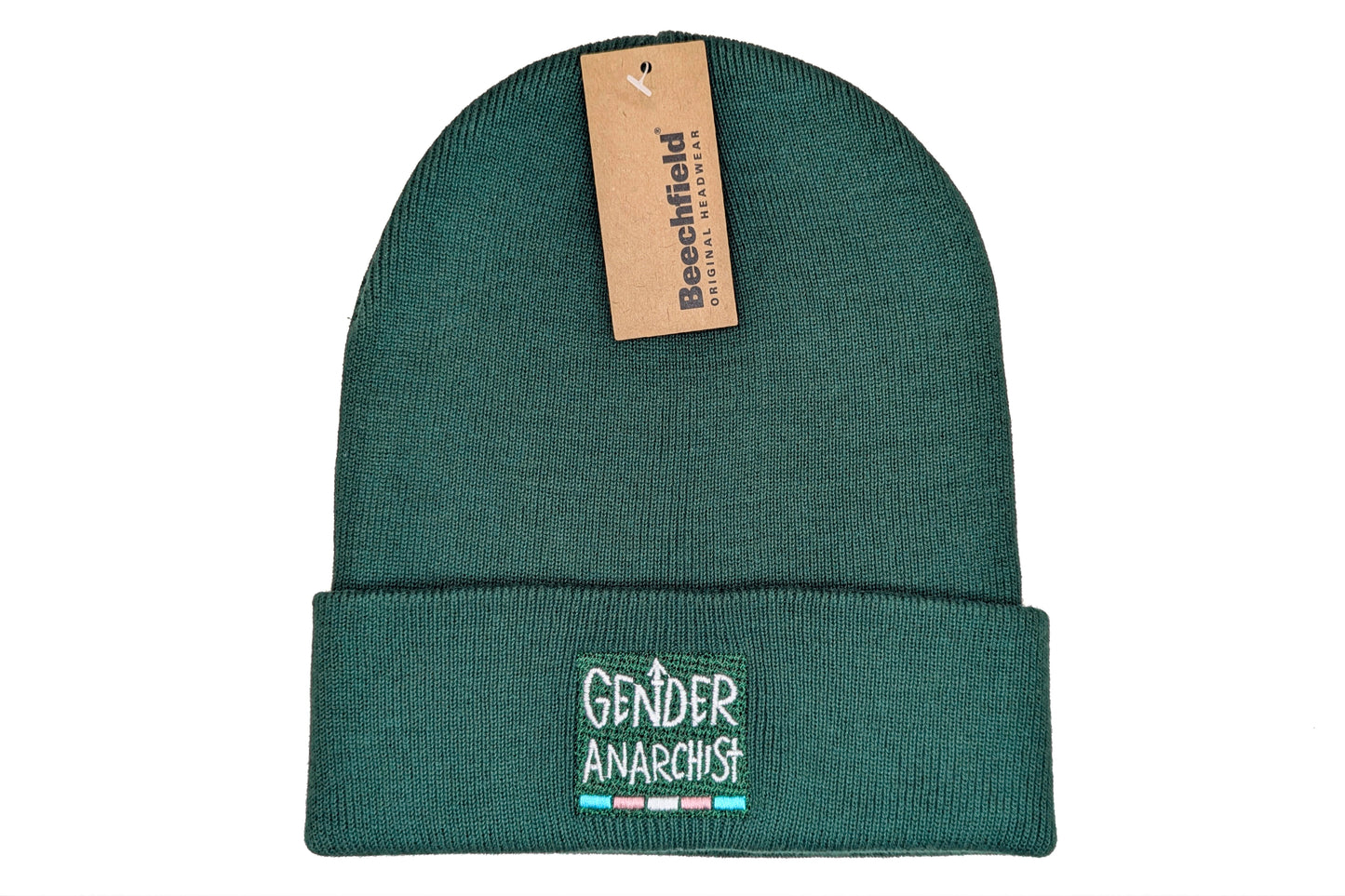 A photo of a bottle green cuffed beanie with a trans pride design embroidered on the cuff. The design consists of white text reading "Gender Anarchist" with a thin band in the trans pride flag colours below it.