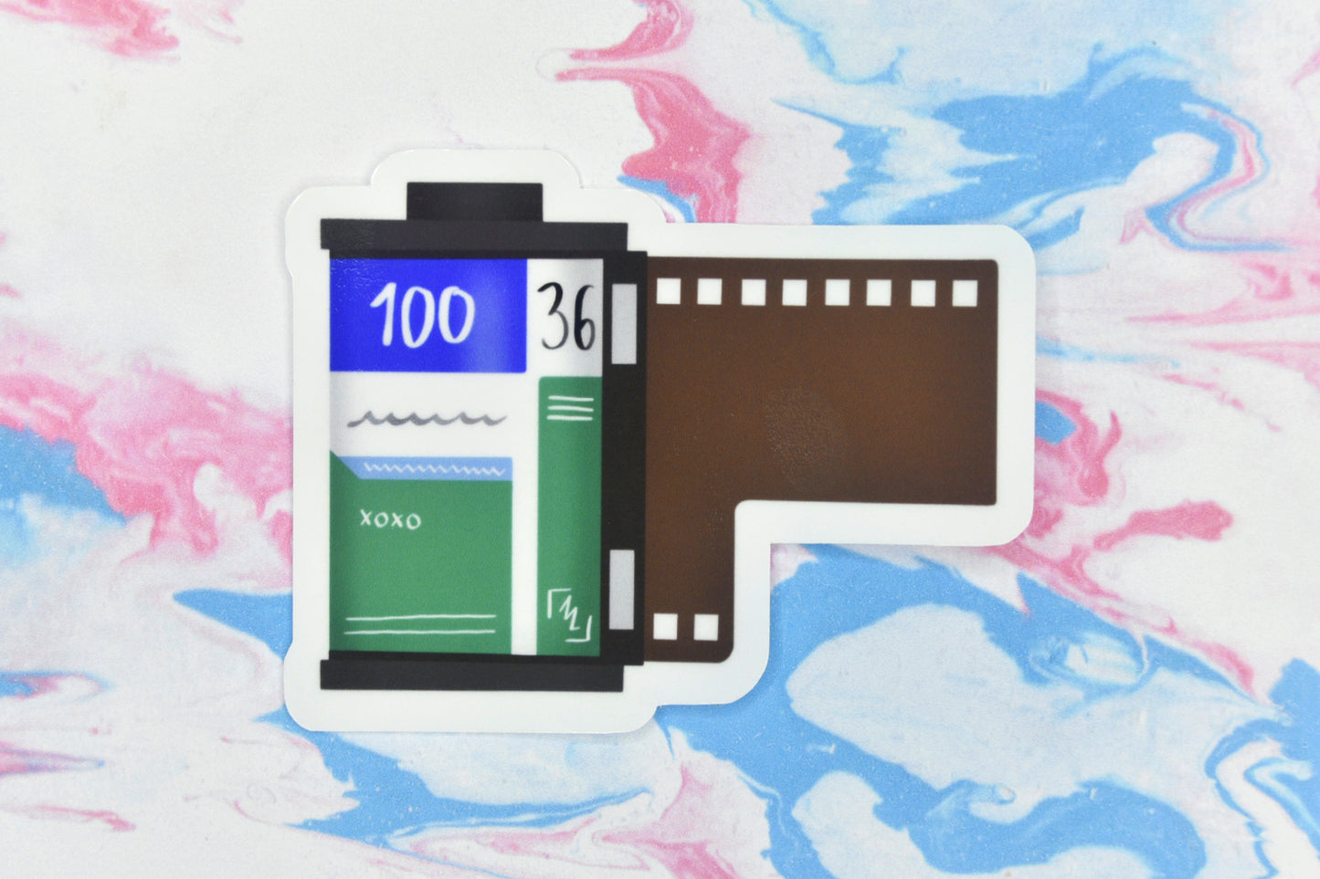 An LGBTQ+ pride vinyl sticker depicting a roll of film in the gay MLM pride flag colours.