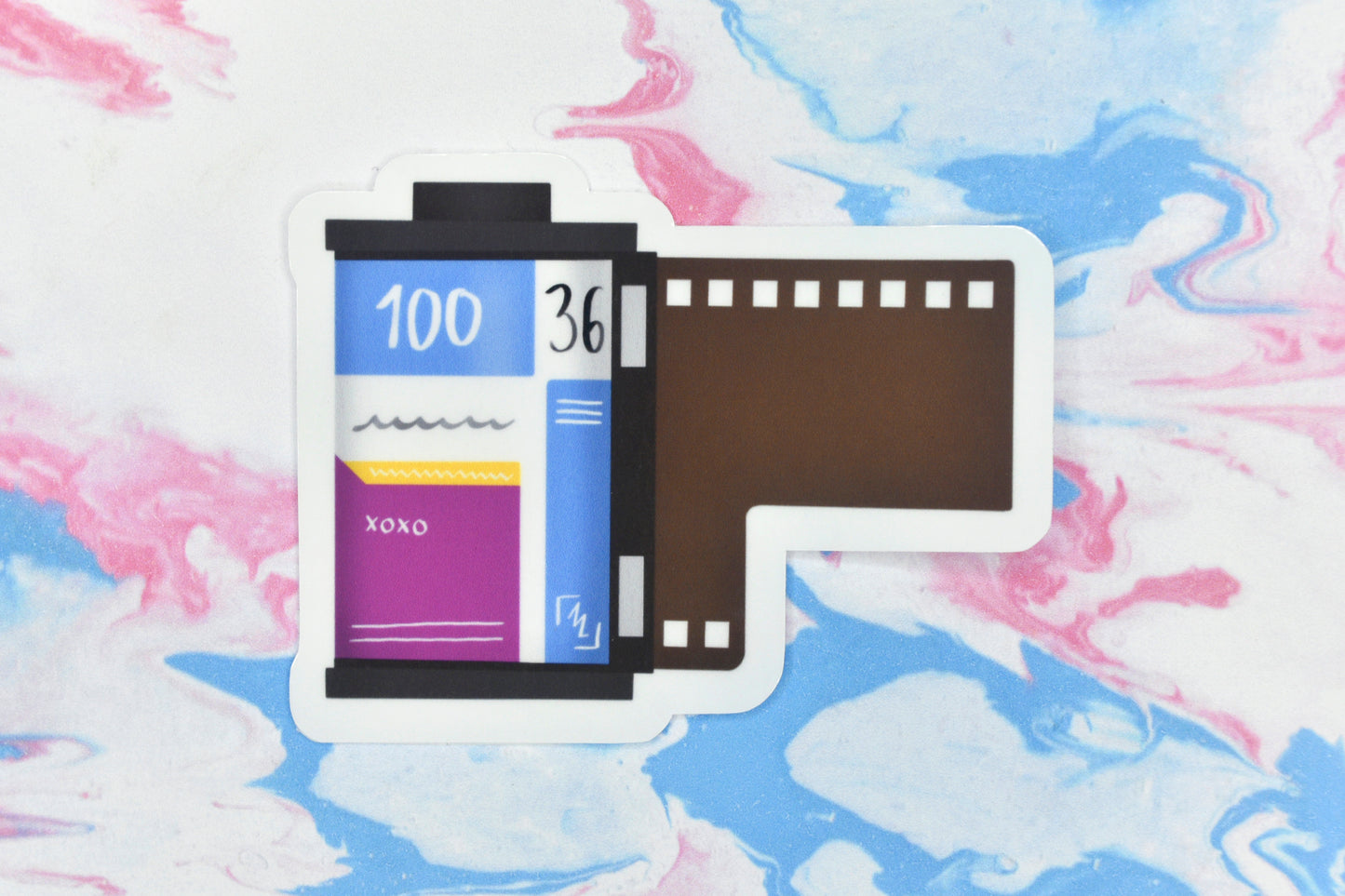 An LGBTQ+ pride vinyl sticker depicting a roll of film in the pansexual pride flag colours.