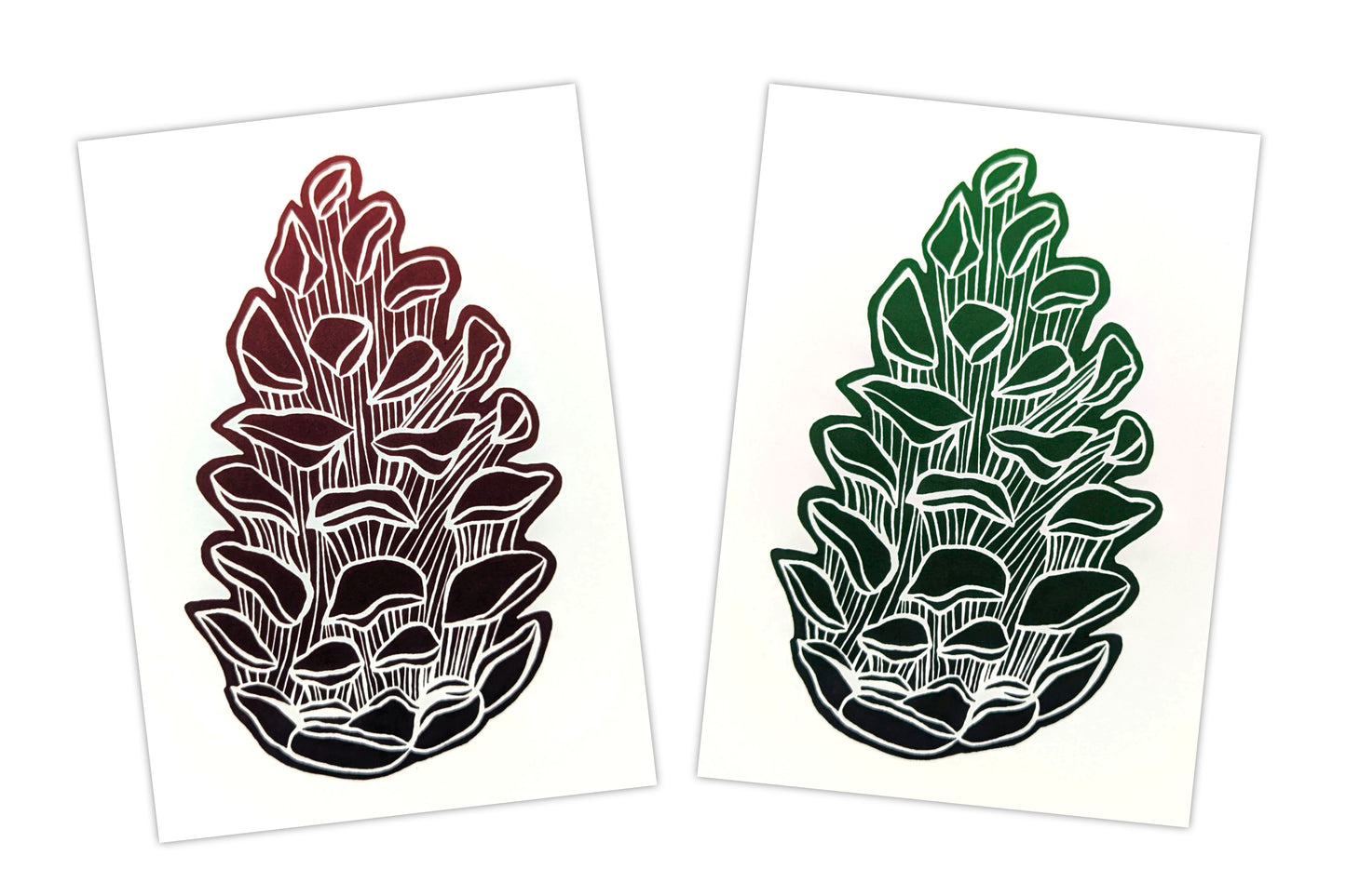Two greeting cards, each featuring a lino print design of a pine cone. One is printed in red ink and the other in green. Both are on a white background.