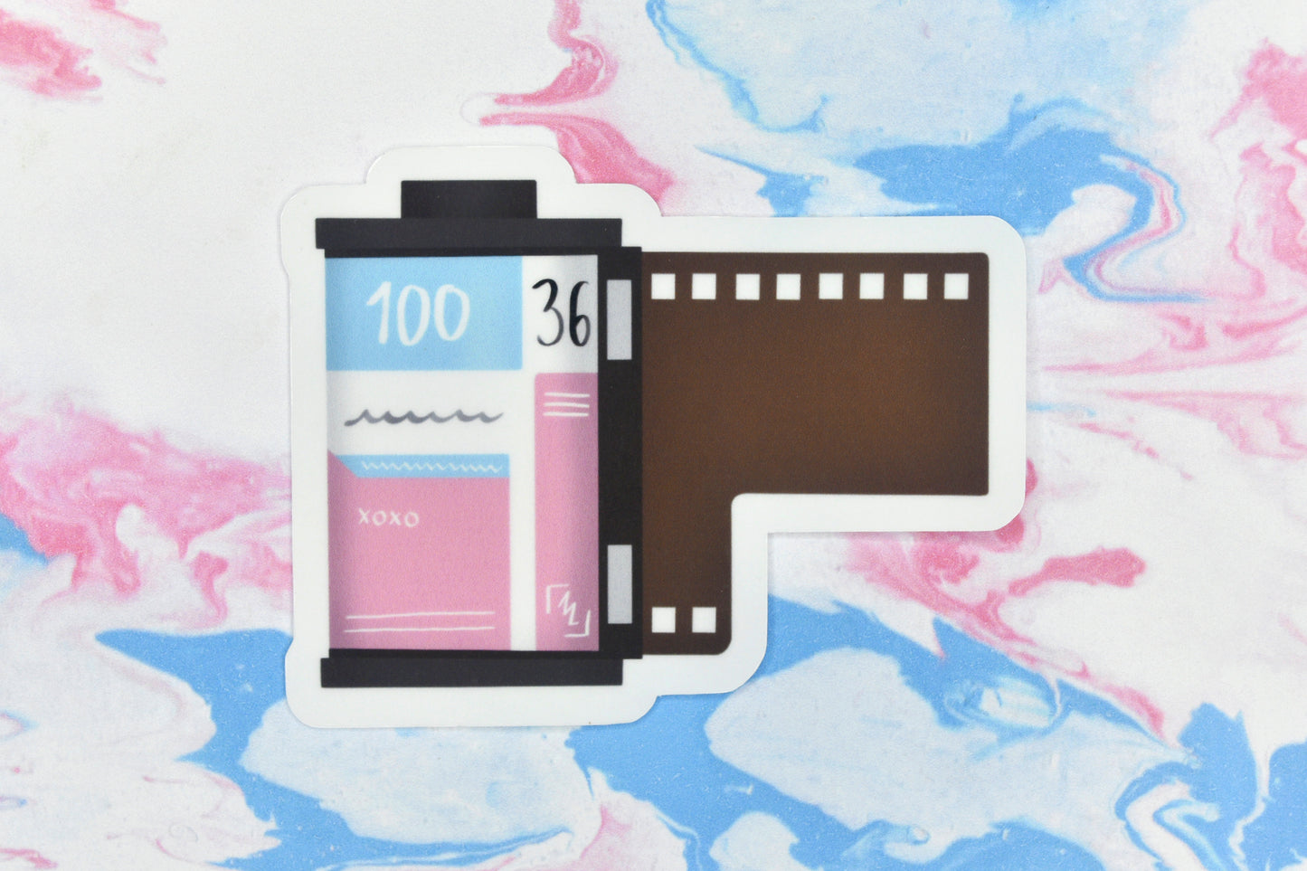 An LGBTQ+ pride vinyl sticker depicting a roll of film in the trans pride flag colours.