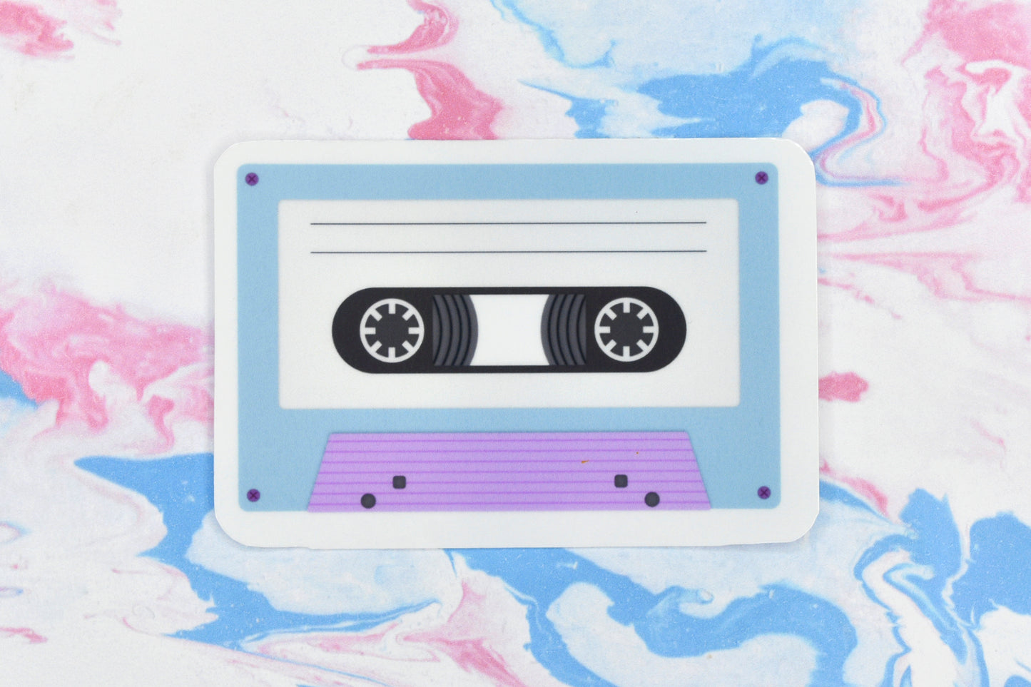 An LGBTQ+ pride vinyl sticker depicting a cassette tape in the trans pride flag colours.