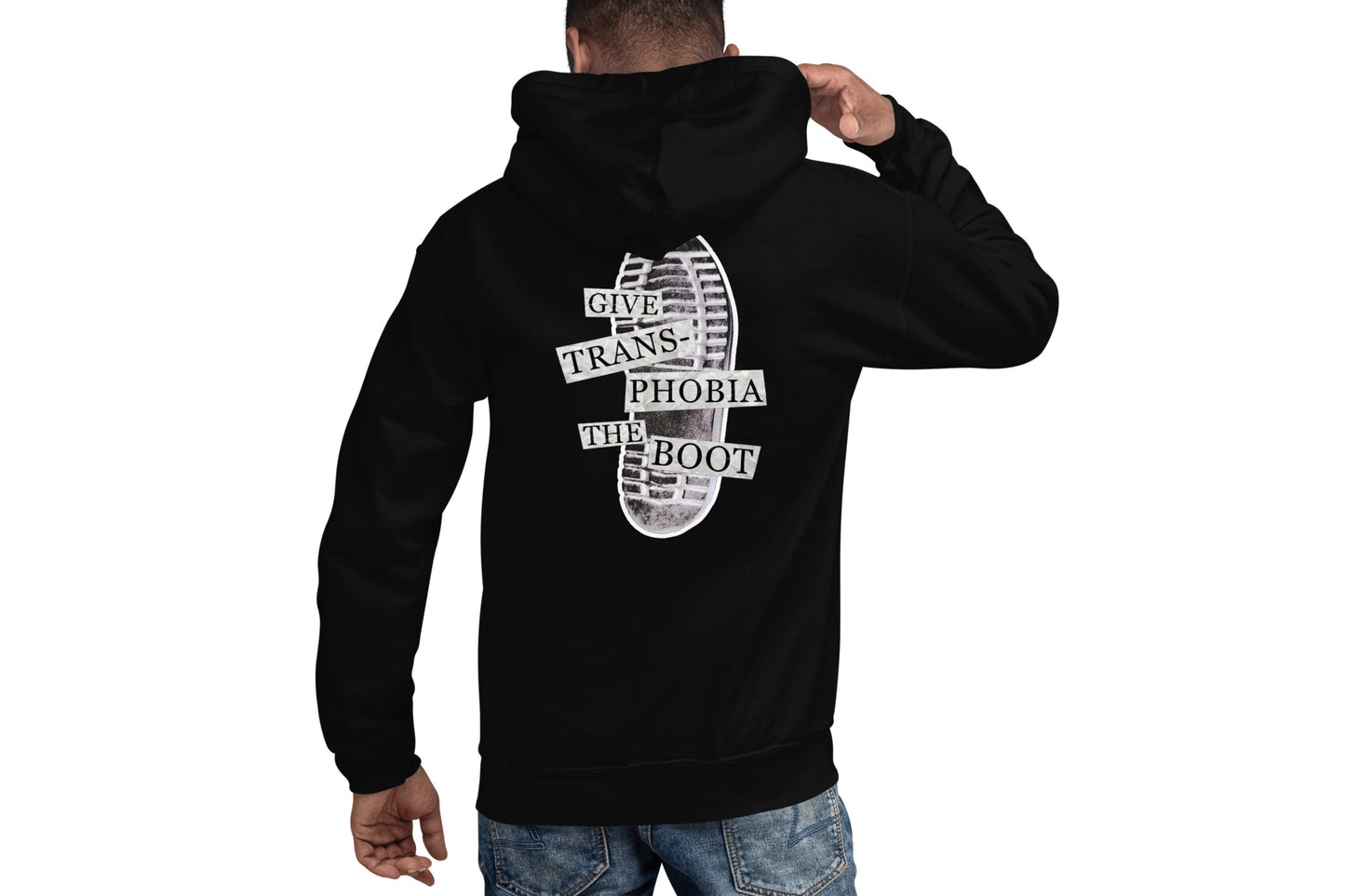 A mock-up of the back of a black hoodie worn by a model. The back of the hoodie features a photograph of the bottom of a black combat boot. There is text overlaid on the photograph in a paper collage style which reads "give transphobia the boot".