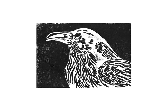 An original lino print depicting the side profile of a crow from the breast up. The background is black with the crow in white.