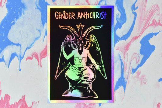 A rectangular holographic sticker with a black and white illustration of Baphomet, a figure with a human torso, a goat's head and hooves, and large angel-like wings. They have top surgery scars, a trans symbol tattoo on their torso and the words "queer" and "liberation" tattooed on their right and left arms respectively. Below Baphomet is white text reading "Gender Antichrist". The white areas of the design have a holographic effect over them which shifts and changes in the light.