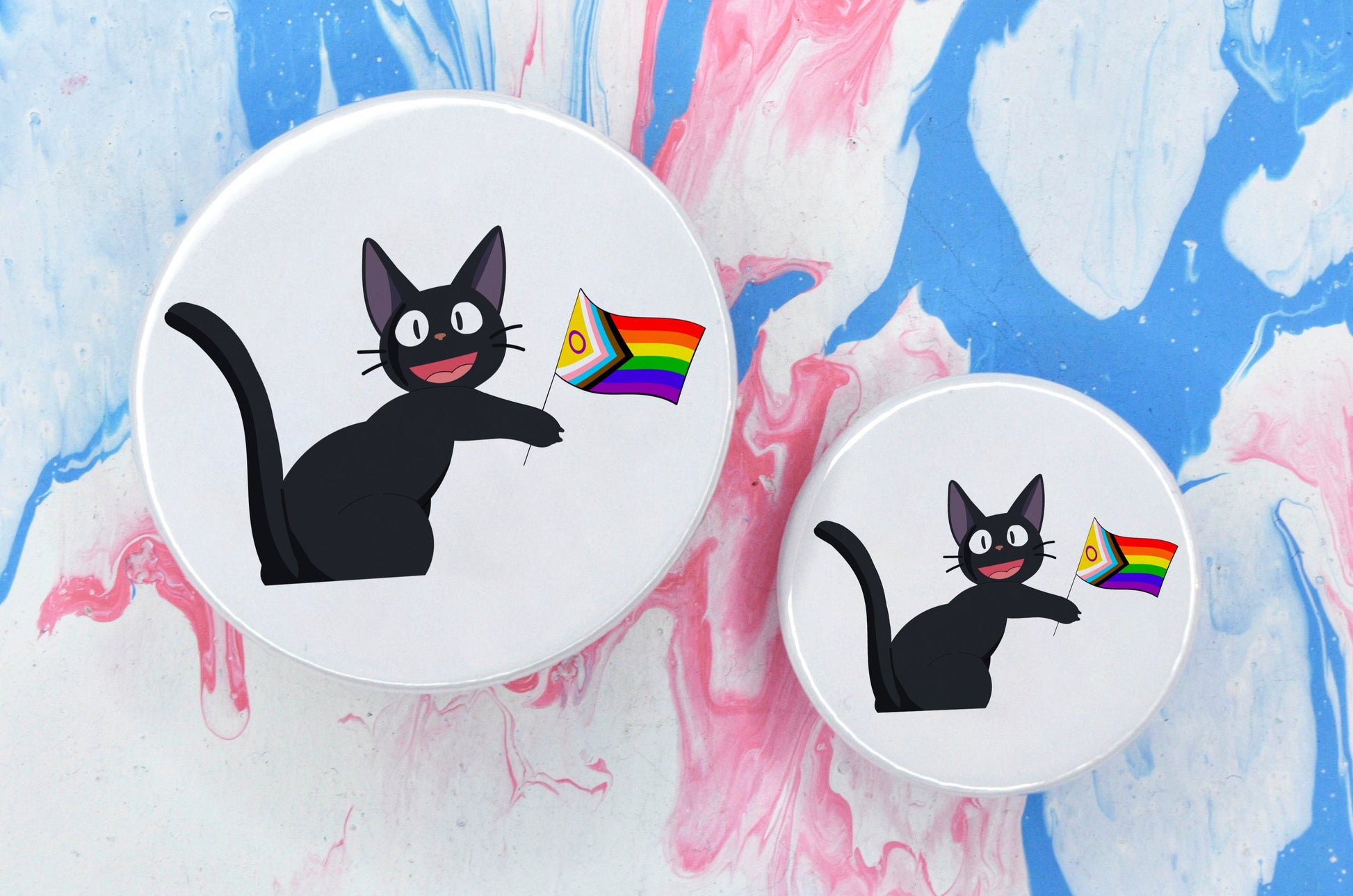 Two pin badges in sizes medium and small, both featuring an illustration of a black anime-style cat holding a progress pride flag. The background of the badge is white.