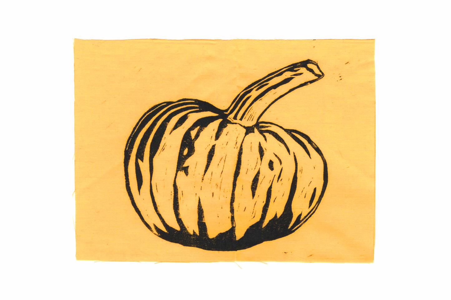 A lino print of a pumpkin, printed in black ink on orange fabric.