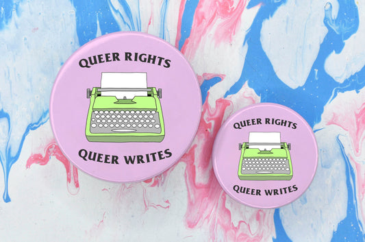 Two pin badges in sizes medium and small, both featuring an illustration of a lime green typewriter on a light pink background. There is text along the top and bottom of the badge reading "Queer rights, Queer writes".