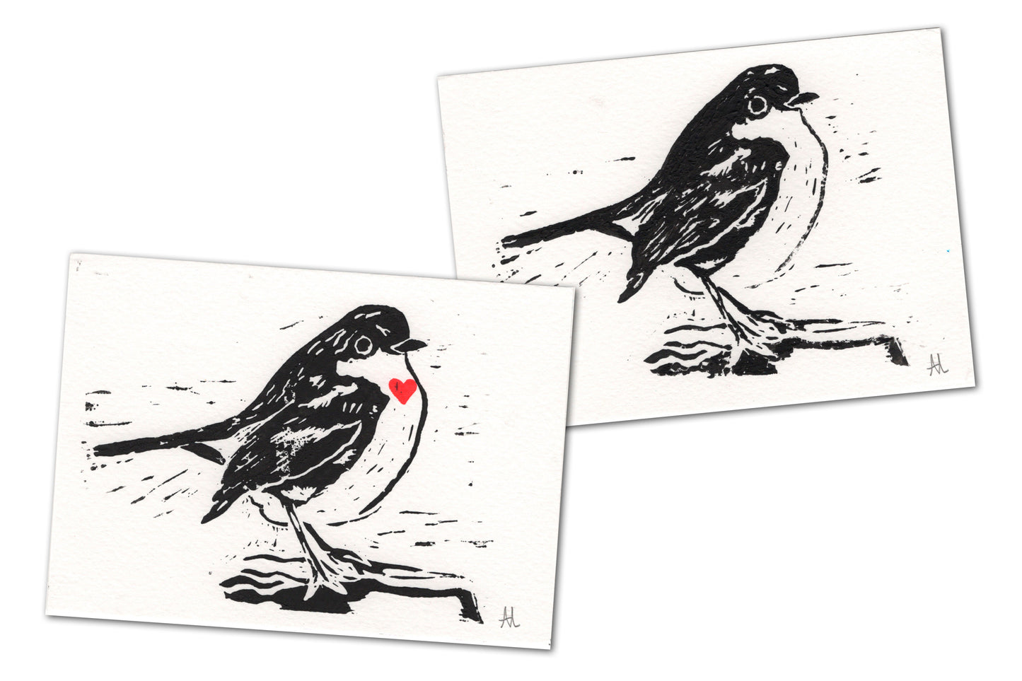 Both versions of the robin lino print, one with a red heart on its chest and one without.