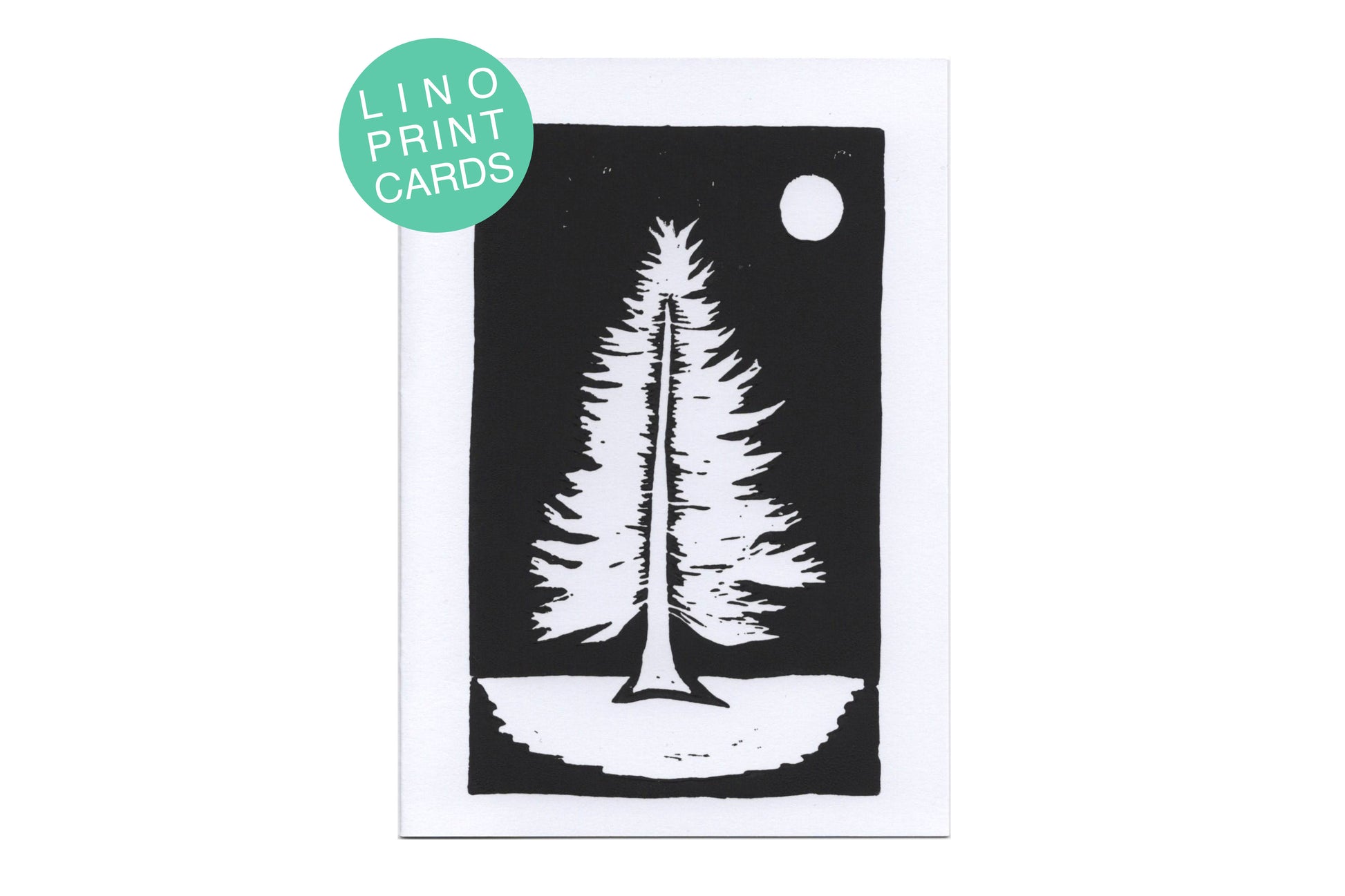 A lino print of a pine tree in black ink on white card. There is a teal circle label in the top left corner with white text reading "lino print cards"